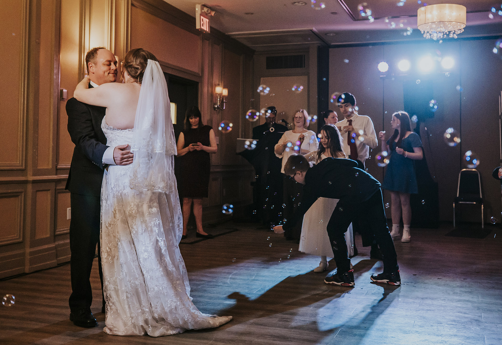 First wedding dance of the bride and groom with attendees helping them with bubbles in a hotel in Sudbury
