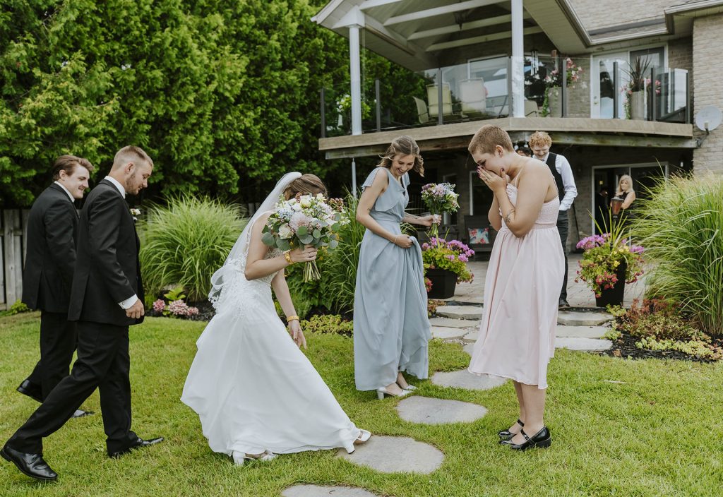 Friends excited looking at the dress and shoes of the bride during an intimate wedding in Sudbury, Ontario captured by a Sudbury Ontario wedding photographer