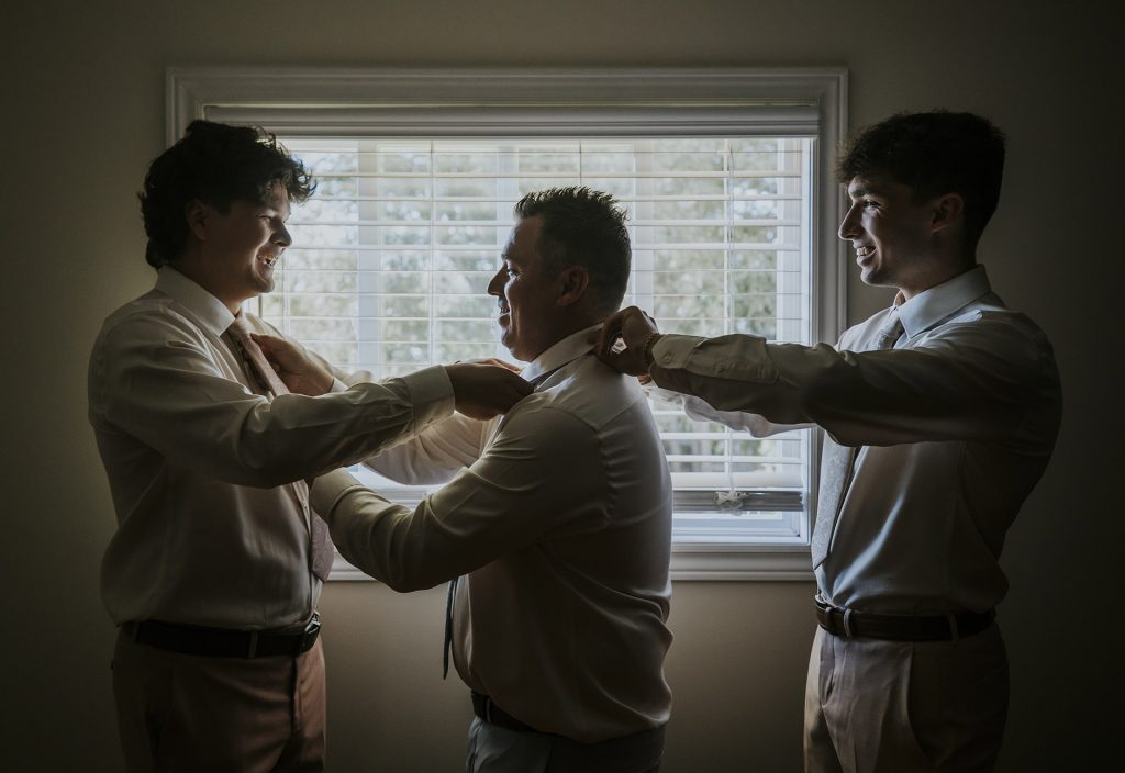 Father with their two kids helping him getting ready on their wedding day in Sudbury, Ontario