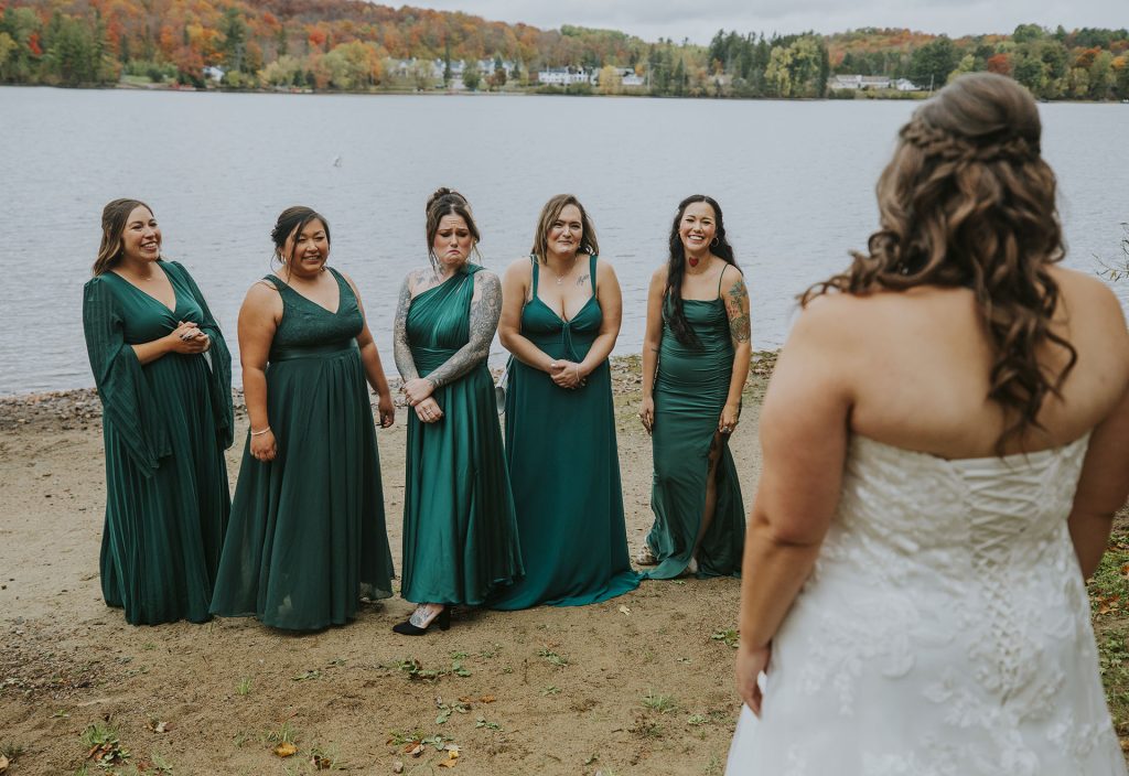 Bridesmaids doing the first look with the bride on her dress in Sudbury, Ontario