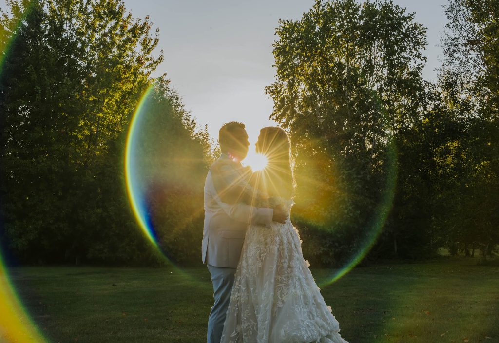Couple hugging and looking at each other with sunset on their backs during their wedding in Sudbury, Ontario